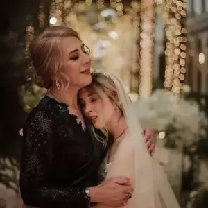 عکس عروس و مادرش در حالی که یکدیگر را در آغوش گرفته اند