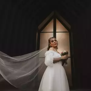 عکس عروس در عمارت در حالی که تورش در اسمان است