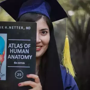 عکس فارغ التحصیلی خانمی که کتاب جلوی صورتش گرفته است